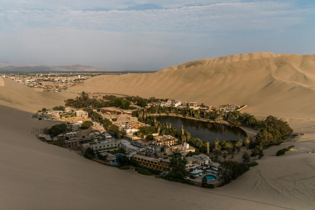 Stunning aerial view of Huacachina oasis surrounded by sand dunes in Ica, Peru.