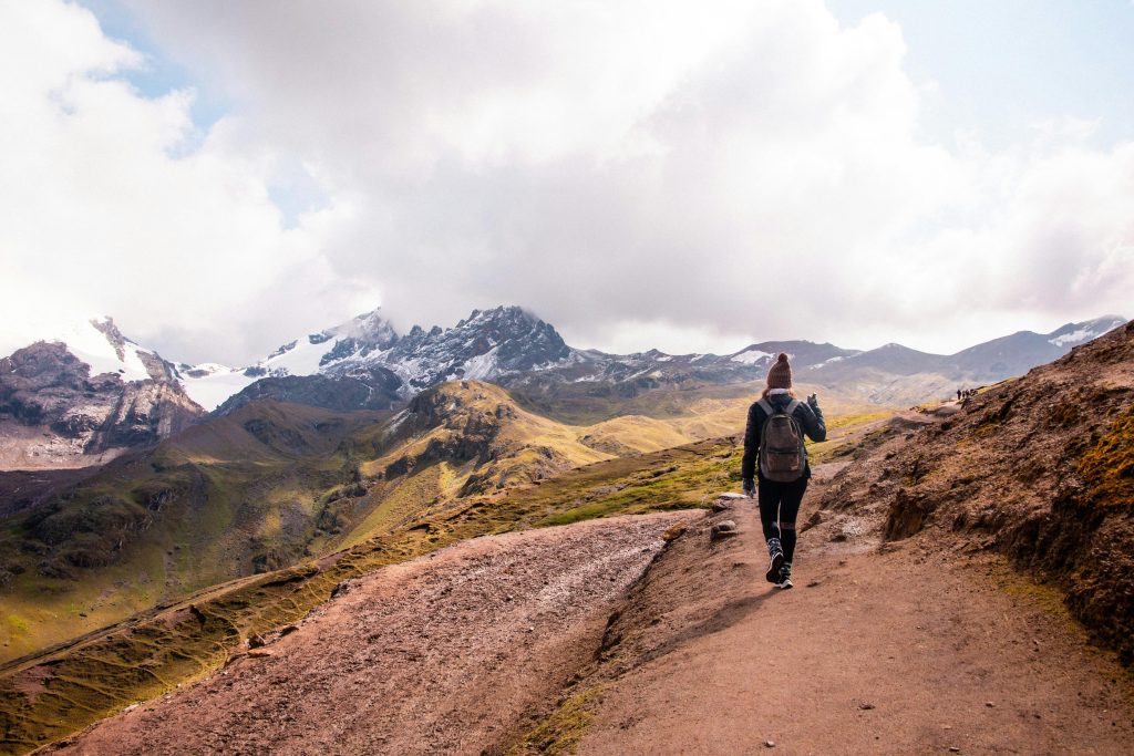 A woman hiking on a scenic trail in the Andes mountains of Cusco, Peru.